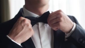 man putting on bow tie attracting women 1